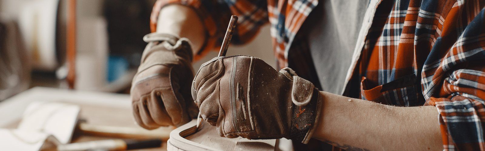 A craftsman marking a piece of wood in his workshop